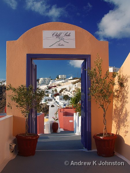 1009_40D_9607.JPG - A charming hotel entrance in Firostephani, with Santorini's iconic white buildings in the background